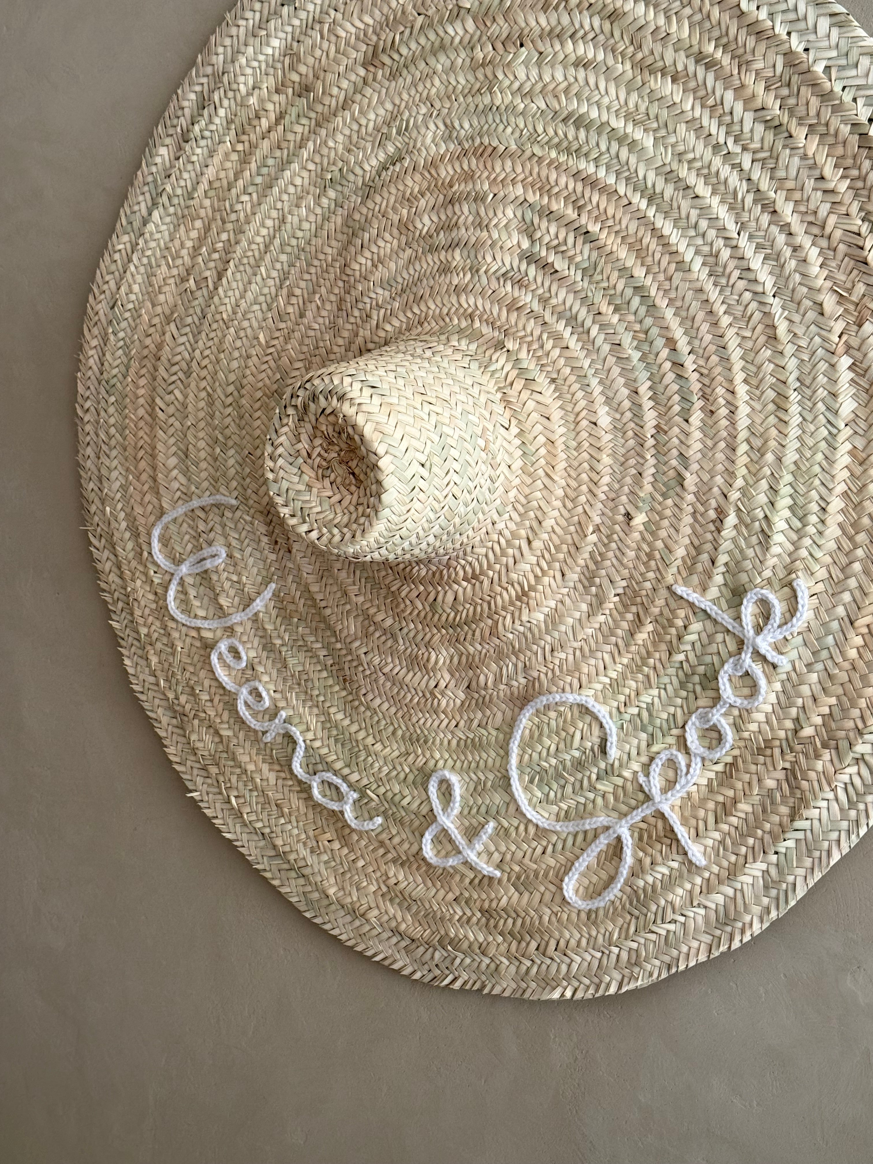 XXL straw hat hung in an entryway — holiday home wall decoration