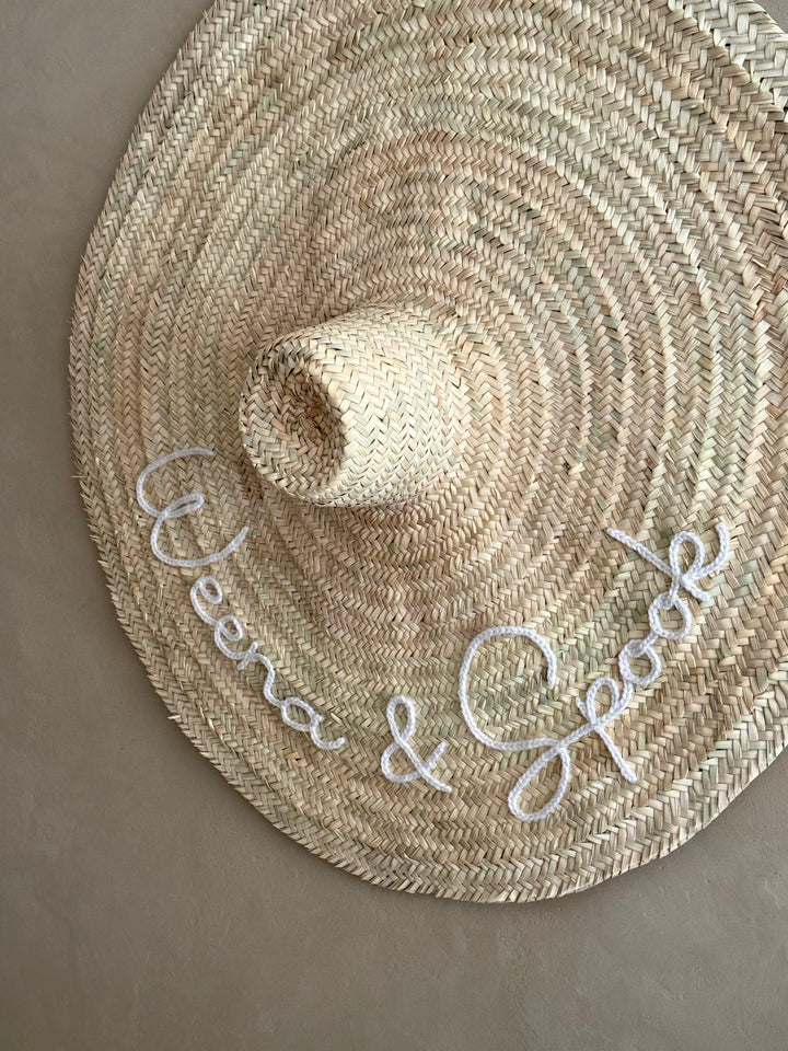 XXL straw hat hung in an entryway — holiday home wall decoration