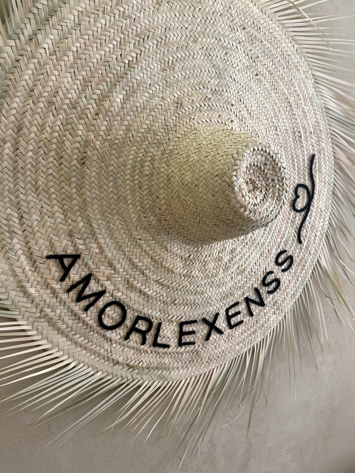 Close-up of hand-embroidered house name on straw wall hat — Beldi Sélection